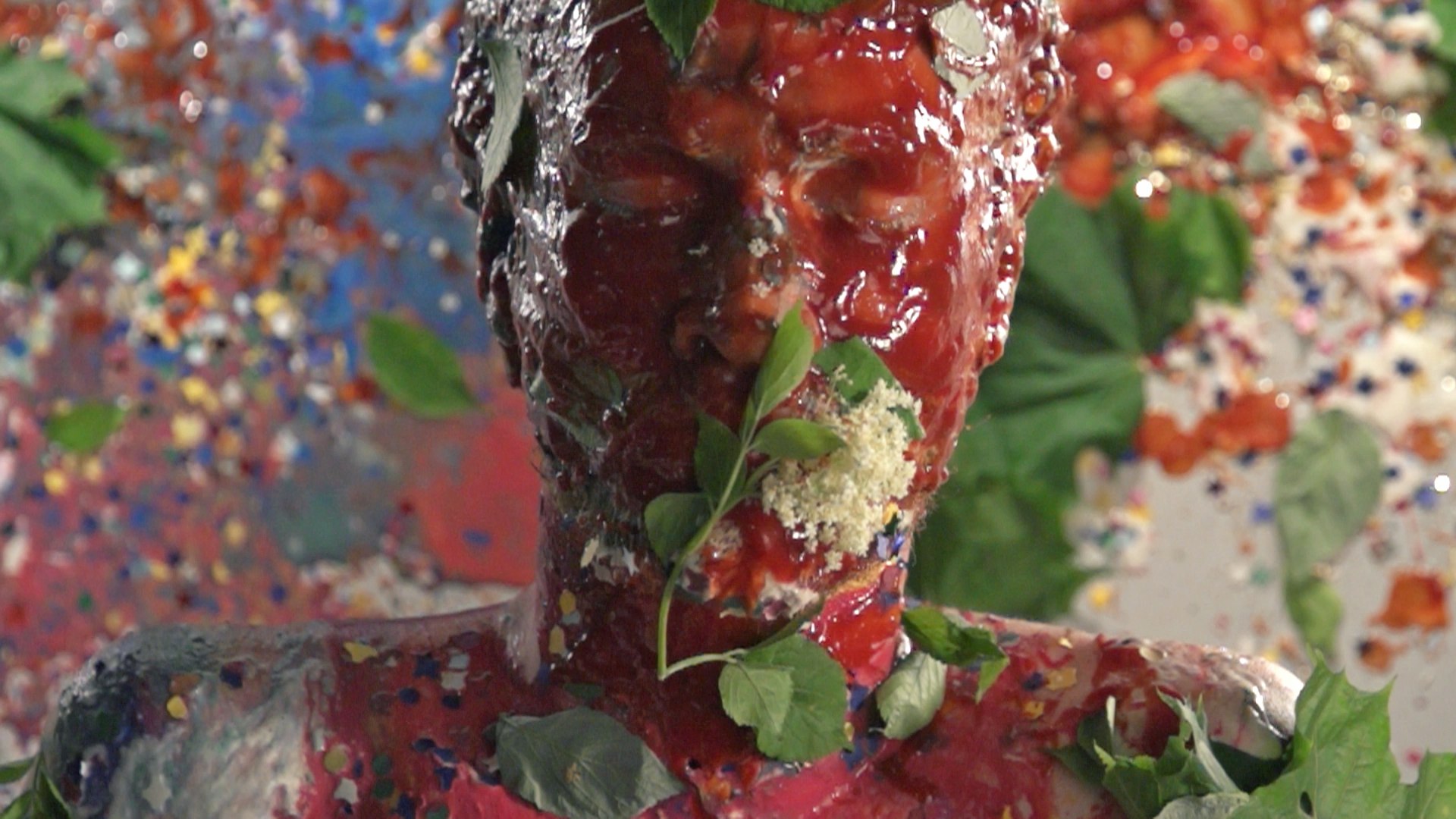 Ketchup und Blumen treffen in Slow Motion das Gesicht des Schauspielers im Musikvideo Spur
